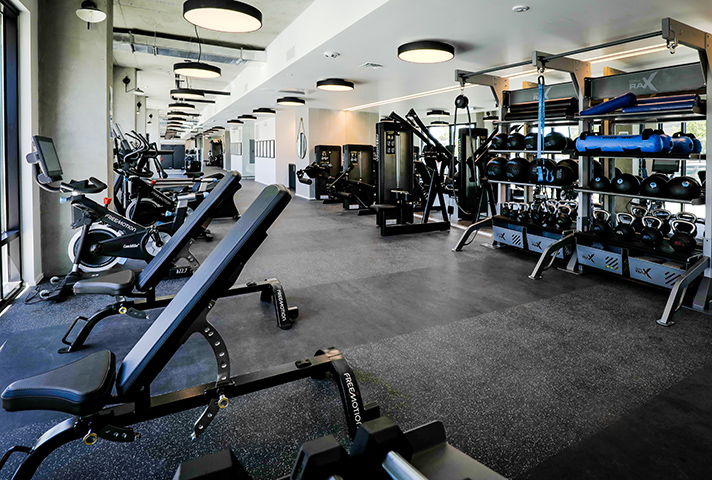 Fitness center with weight equipment and large windows.