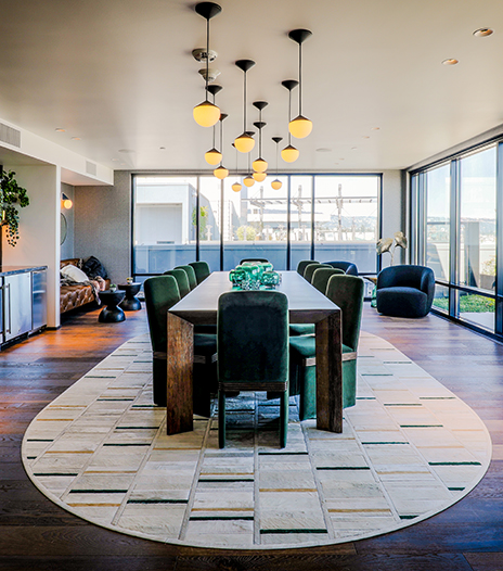 Community space with a large conference table and plush chairs with floor-to-ceiling windows.